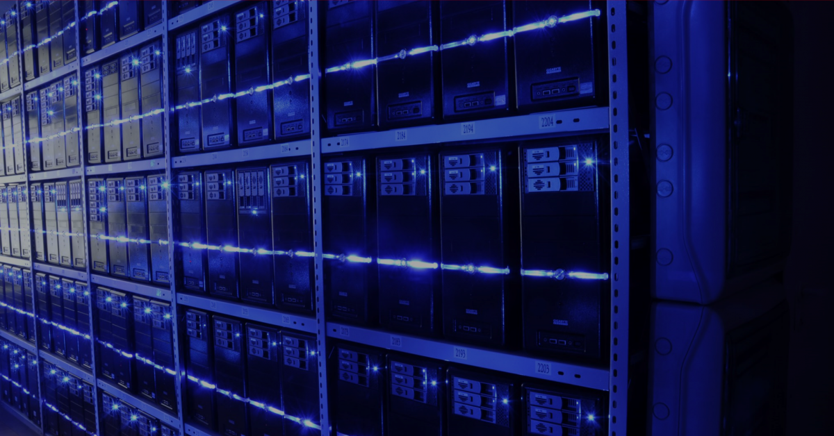 Sistemas computacionais em uma sala de um centro de dados, também conhecido por data center. Ambiente iluminado por luz em tom azul.