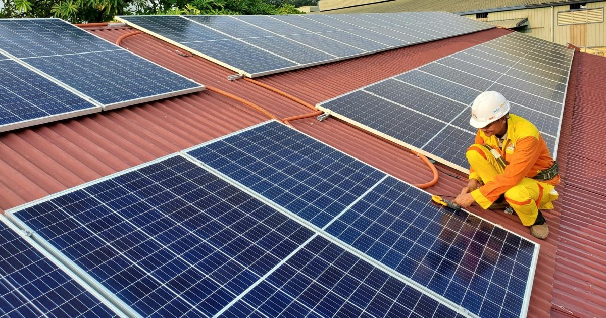 trabalhador instala painel de energia solar fotovoltaica em telhado