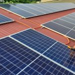 trabalhador instala painel de energia solar fotovoltaica em telhado