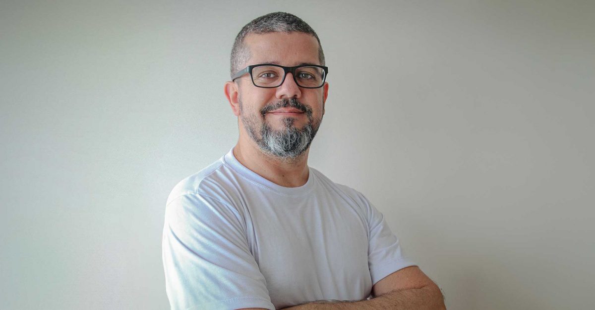 Retrato de Ivo Machado, diretor do Ibrace, de camiseta branca e braços cruzados