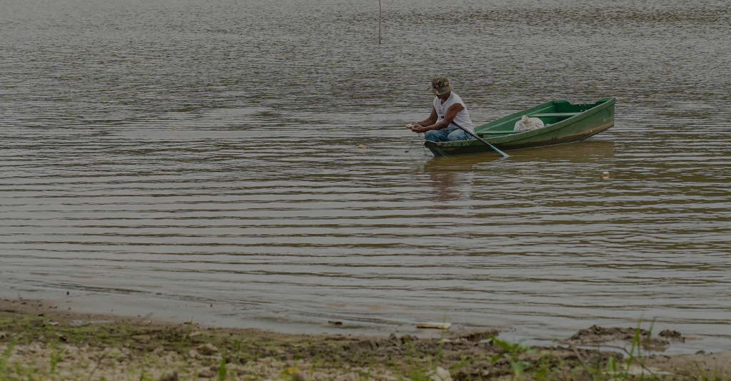 Pescador em barco na Ponta da Piraíba, no rio Araguaia em Manaus, Brasil. A foto mostra o rio seco.