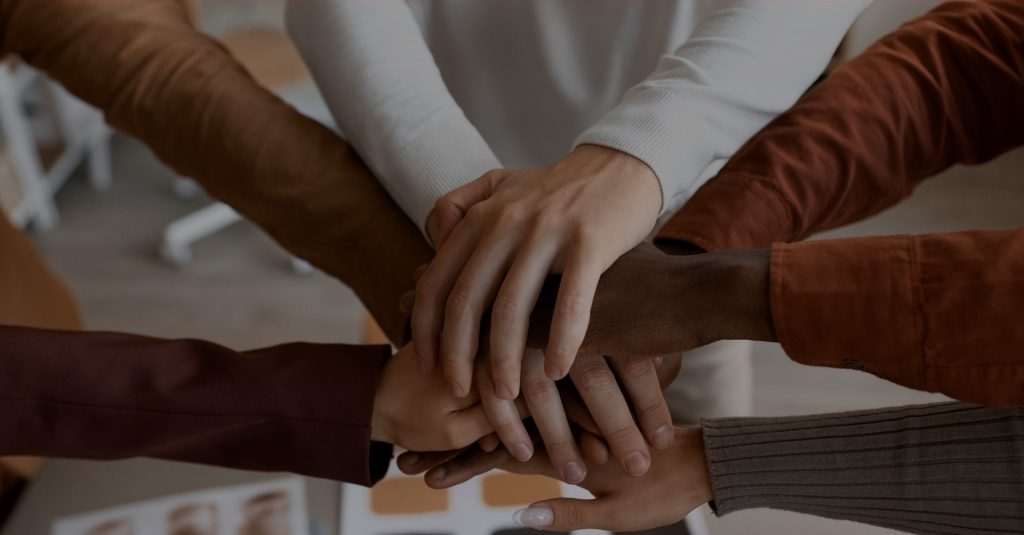 Equipe engajada com as mãos unidas