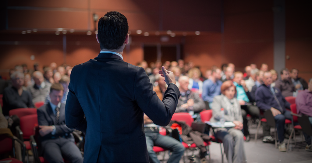 Pessoas acompanhando palestra em auditório