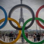 Arcos dos Jogos Olímpicos e Torre Eiffel ao fundo