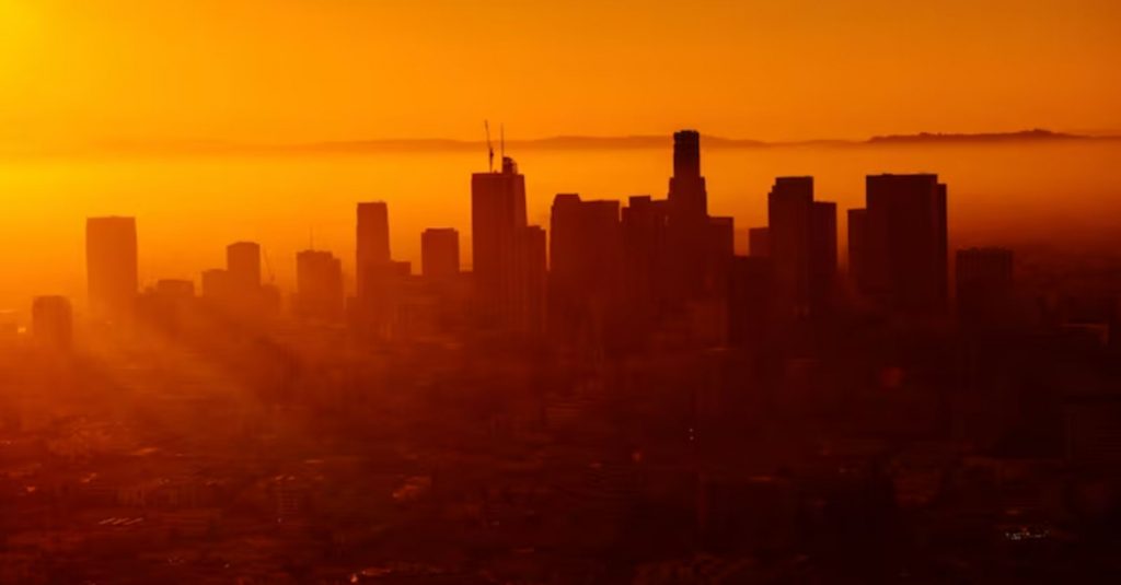 Silhueta de cidade em tons alaranjados, devido às fortes ondas de calor