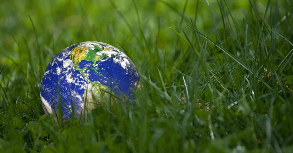 Montagem mostra um globo terrestre sobre um campo gramado